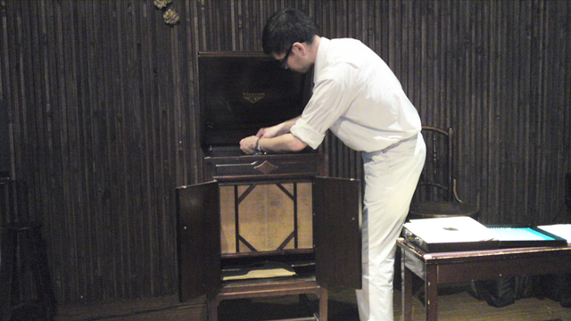 蓄音機にSPレコードをセッティングする成田さん