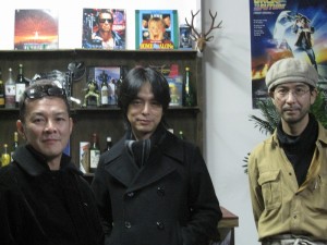 清水さんと似て非カフェに作られた映画セットの前で。右は似て非カフェオーナーの笠原さん